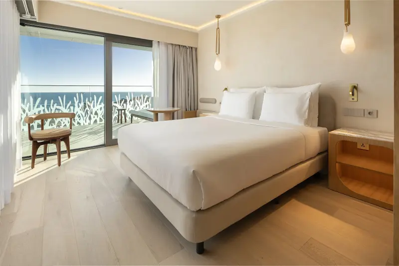Une chambre lumineuse avec un grand lit et une vue sur la mer.