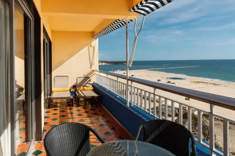 Une terrasse ensoleillée offre une vue dégagée sur la plage et la mer.