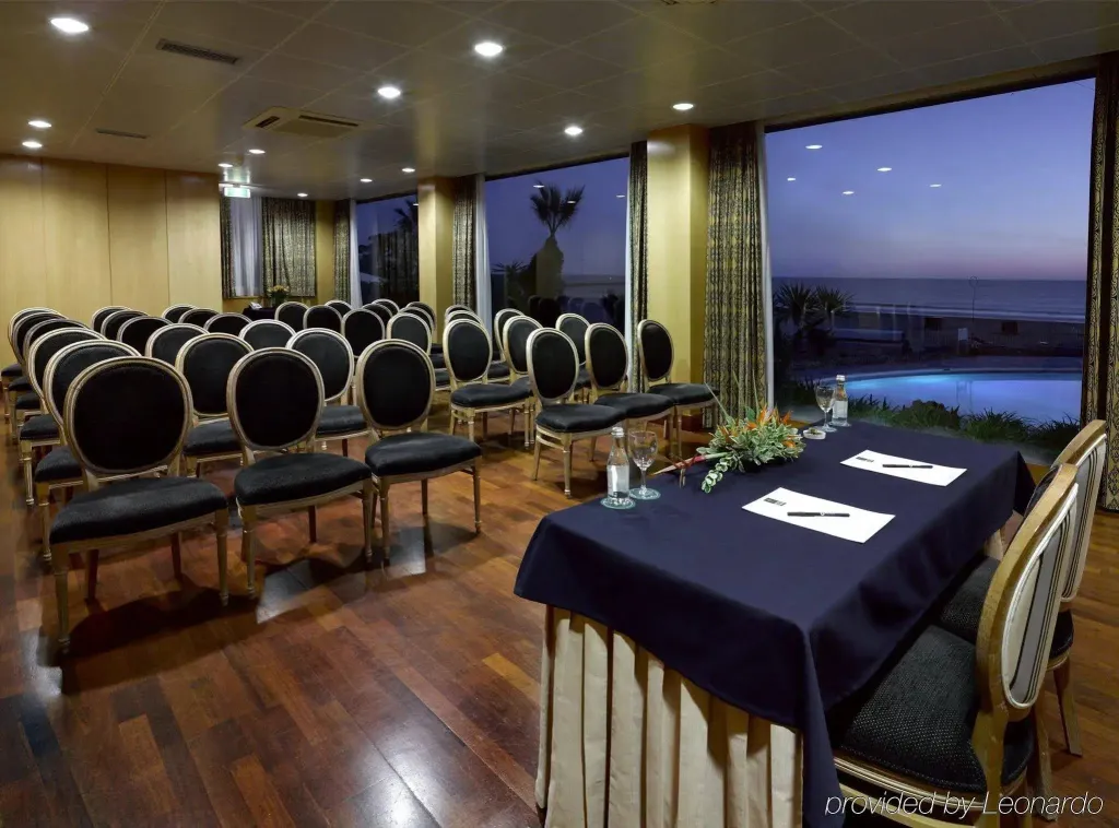 Une salle de réunion lumineuse avec vue sur la mer et une piscine.