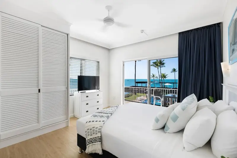 Une chambre lumineuse avec un grand lit et une vue sur la mer.