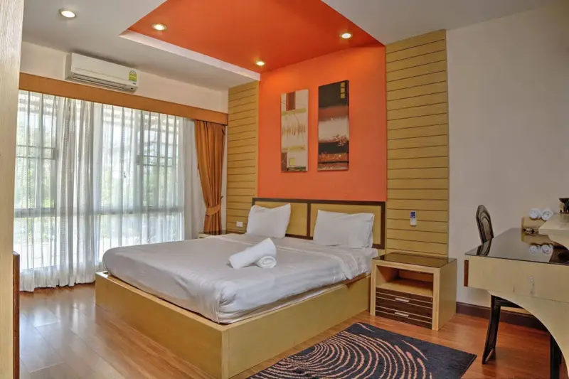Une chambre lumineuse avec un grand lit et des tableaux décoratifs.