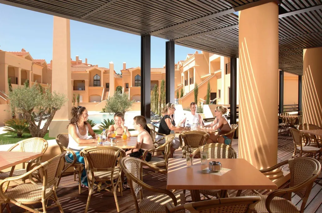 Des convives sont assis à des tables en terrasse pour déguster des boissons.