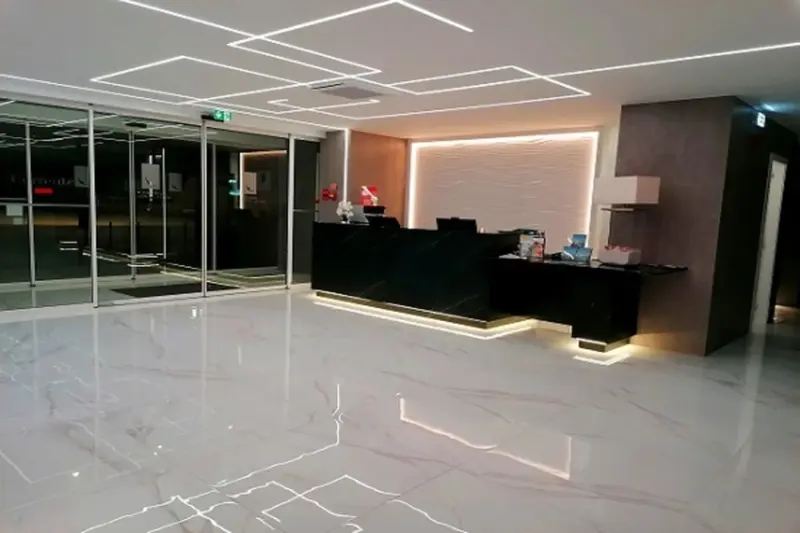 Un comptoir d'accueil moderne dans un hall spacieux et lumineux.