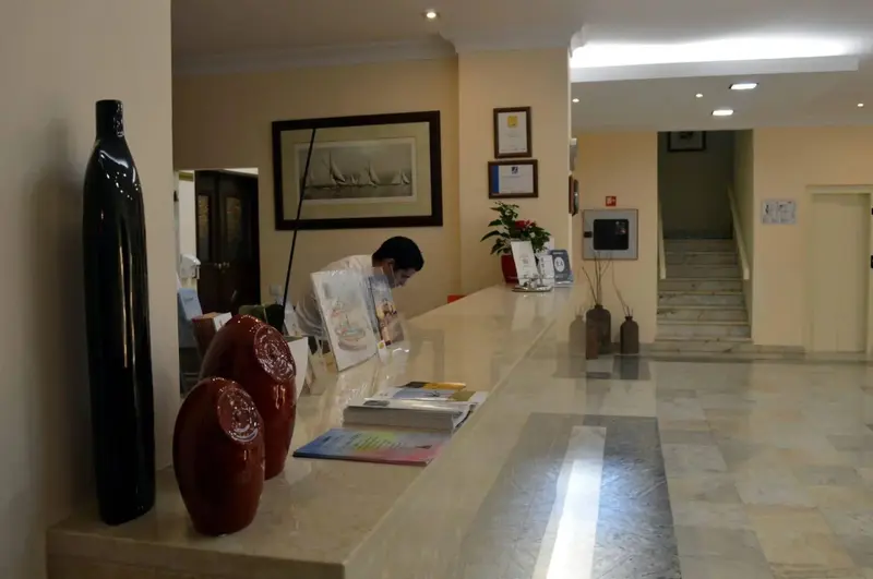 Un comptoir d'accueil lumineux avec une personne en train de lire des documents.