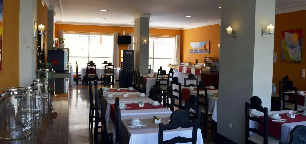 Une salle lumineuse avec des tables dressées pour le repas.