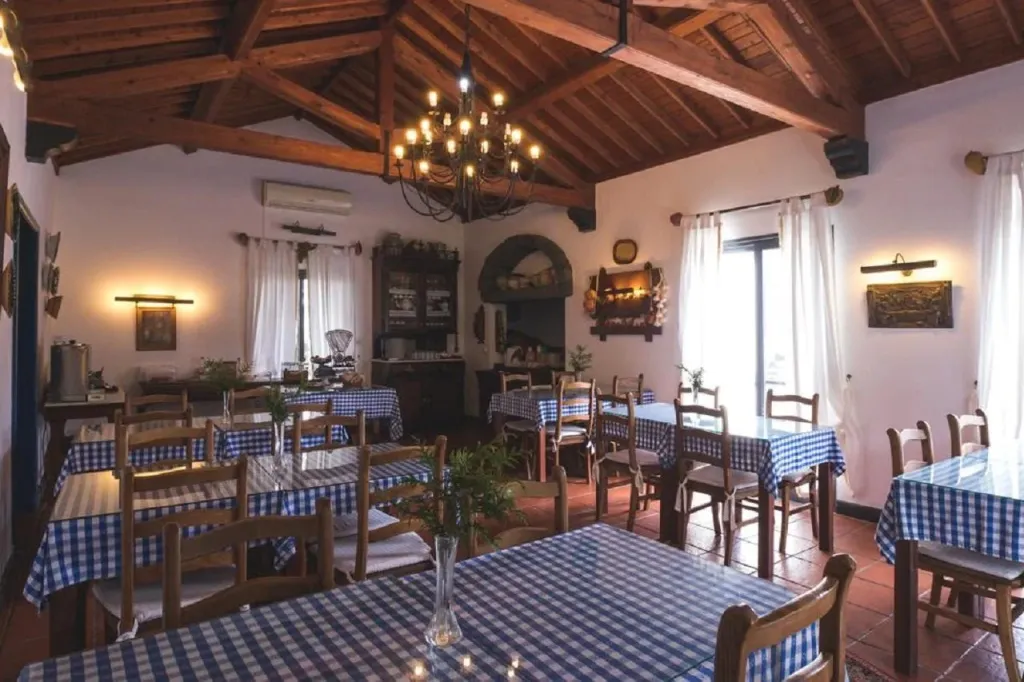 Une salle lumineuse avec des tables nappées et un lustre central.