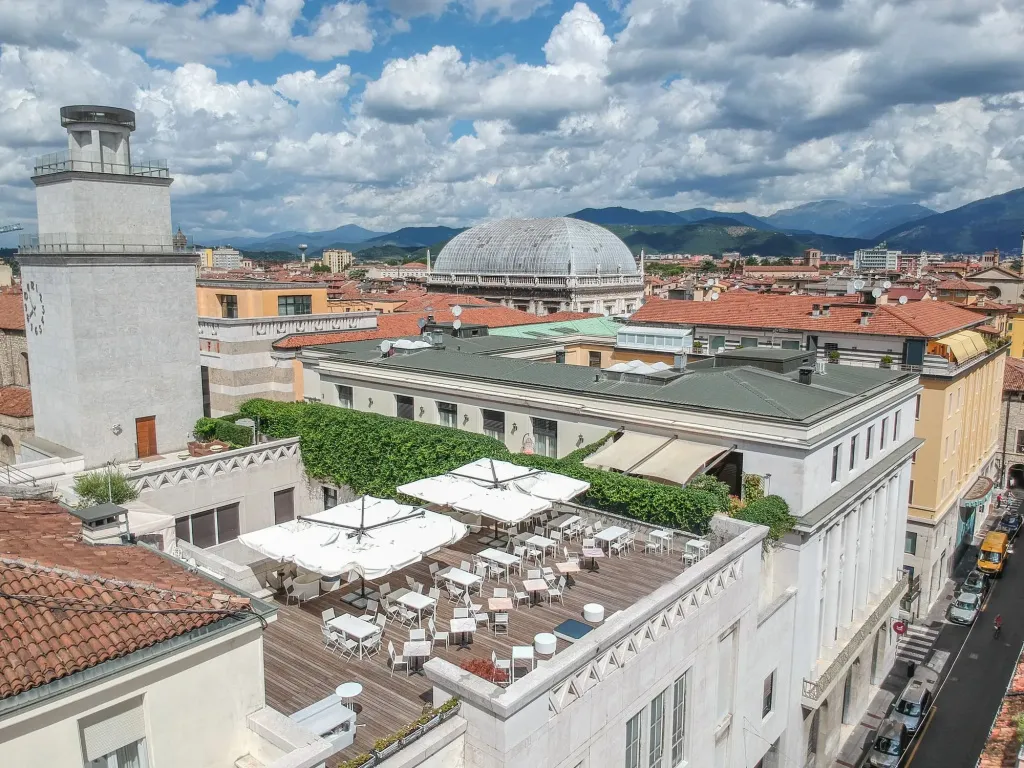 Terrasse aménagée avec tables et parasols offrant une vue sur la ville.