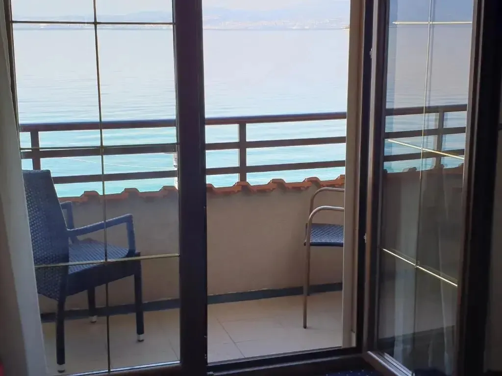 Vue sur la mer depuis un balcon avec mobilier d'extérieur.