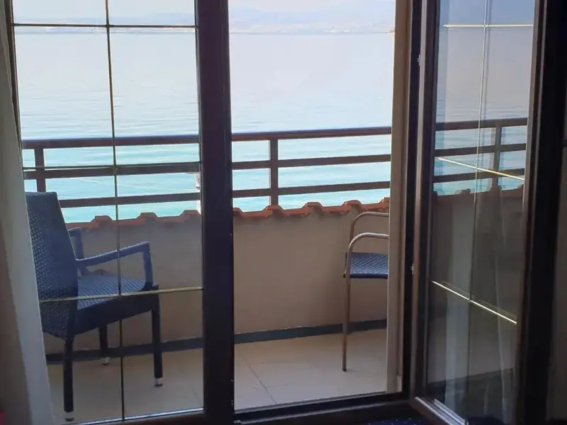 Vue sur la mer depuis un balcon avec mobilier d'extérieur.