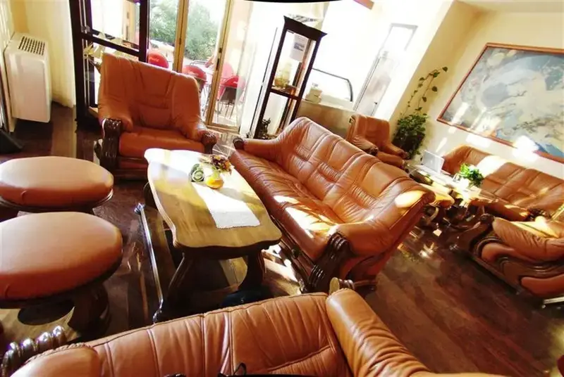 Un espace de détente intérieur avec des canapés et des fauteuils en cuir.