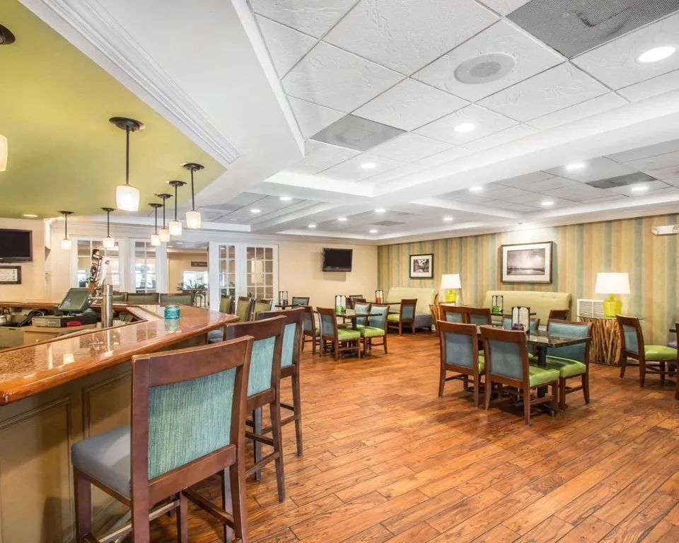 Une salle lumineuse avec un comptoir de bar et des tables à manger.