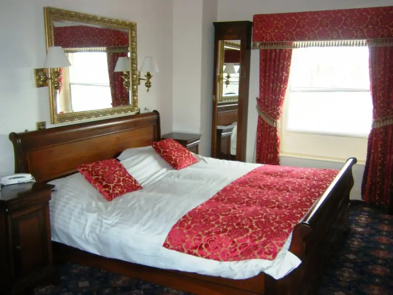 Une chambre à coucher avec un grand lit et des meubles en bois.