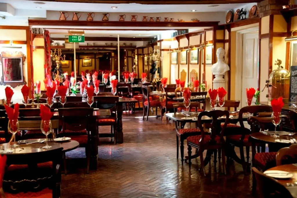 Une salle de restaurant élégante avec des tables dressées et une décoration soignée.