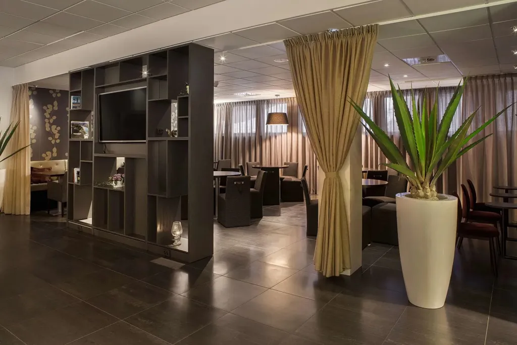 Espace de détente intérieur avec bibliothèque et tables basses.