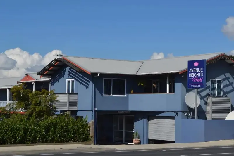 Façade d'un bâtiment bleu à deux étages avec un panneau indiquant un motel.