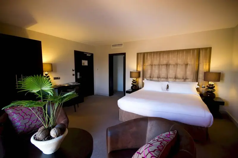 Une chambre lumineuse avec un grand lit et un coin salon.
