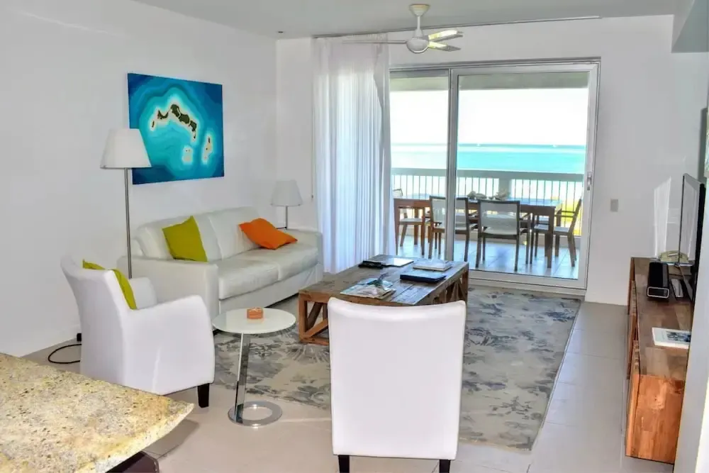 Un salon lumineux s'ouvre sur une terrasse avec vue sur la mer.