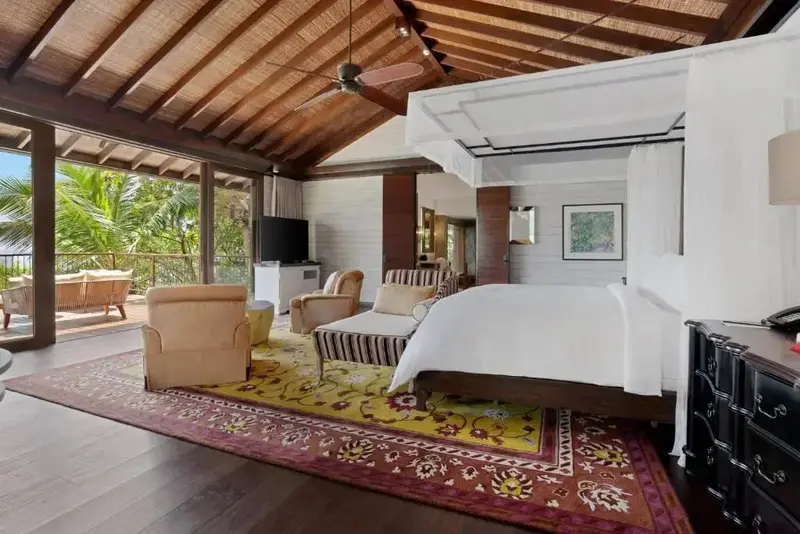 Une chambre spacieuse avec un lit à baldaquin et un accès à une terrasse.