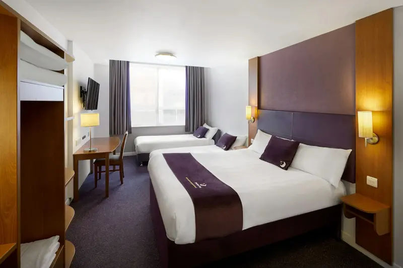 Une chambre d'hôtel moderne avec deux lits et un bureau.