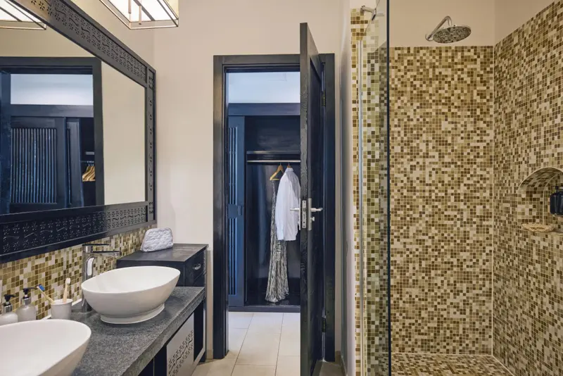 Une salle de bain moderne avec une douche à l'italienne et un lavabo sur un plan vasque.