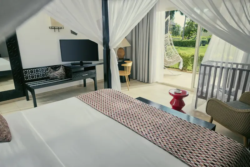 Une chambre lumineuse avec un lit recouvert d'une courtepointe décorative.