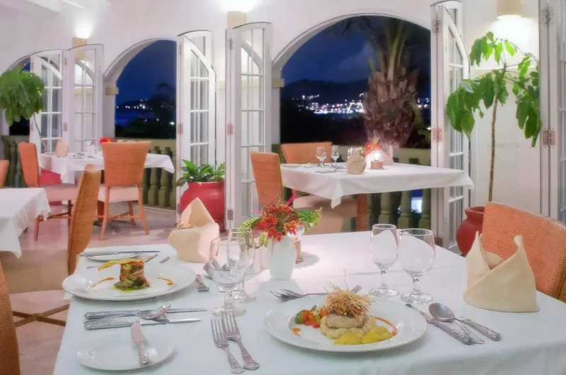 Une table est dressée avec des assiettes et des couverts dans une salle lumineuse.