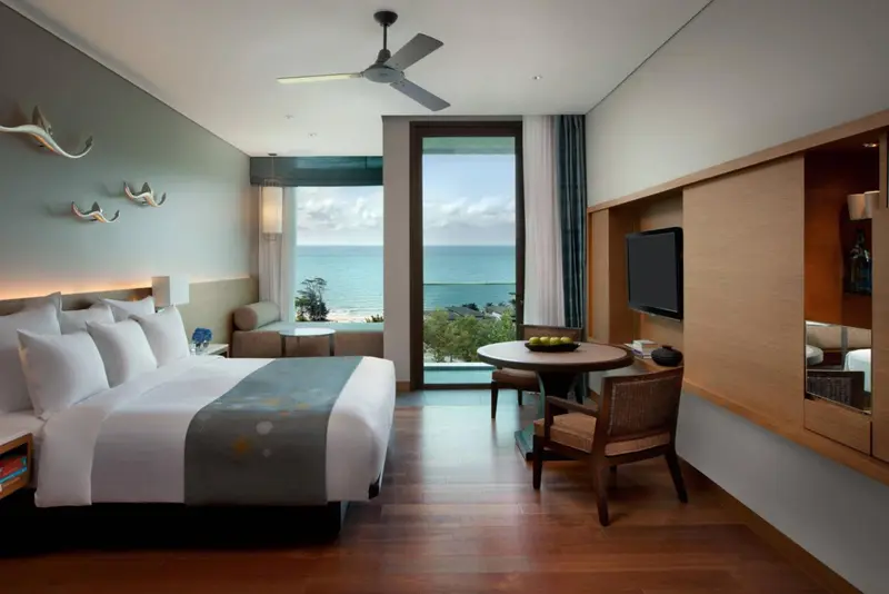 Une chambre lumineuse avec un grand lit donnant sur la mer.
