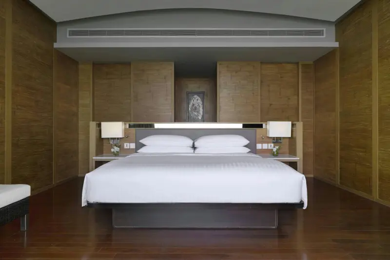Une chambre lumineuse avec un grand lit recouvert de linge blanc.