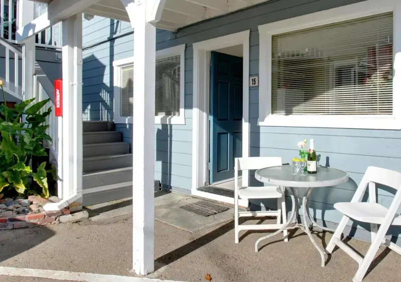 Une terrasse avec une table et des chaises devant une porte bleue.