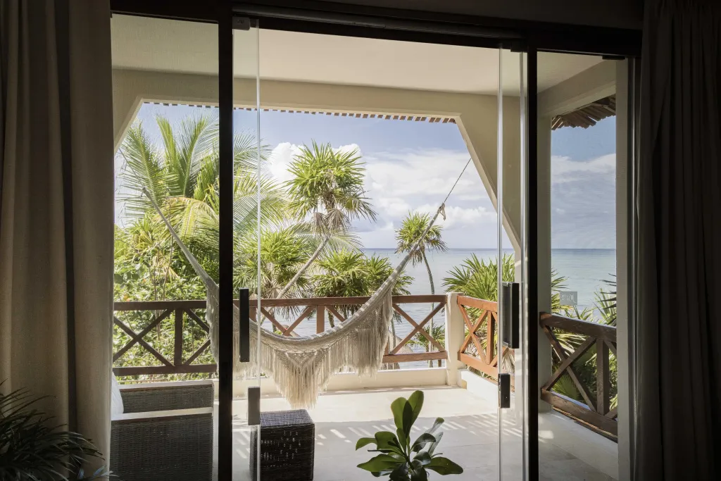 Une hamac est suspendu sur une terrasse avec vue sur la mer.