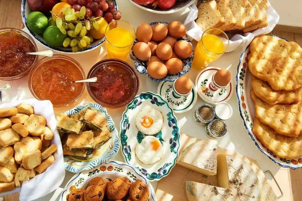 Une table généreusement garnie de divers mets et boissons pour le petit-déjeuner.