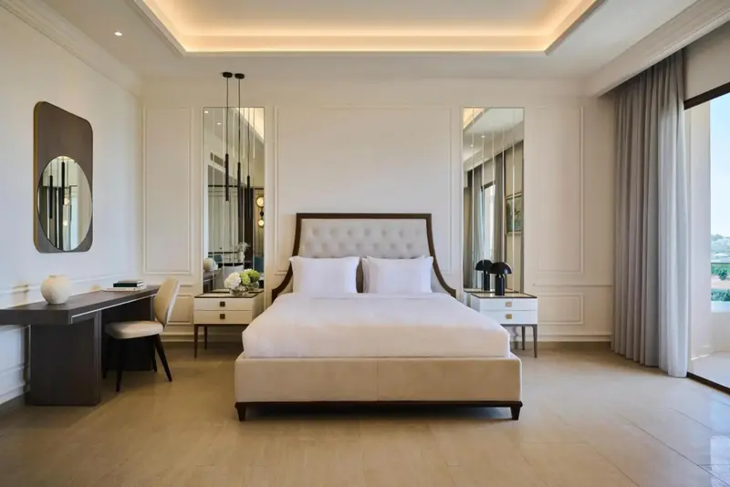 Une chambre lumineuse avec un grand lit et des miroirs décoratifs.