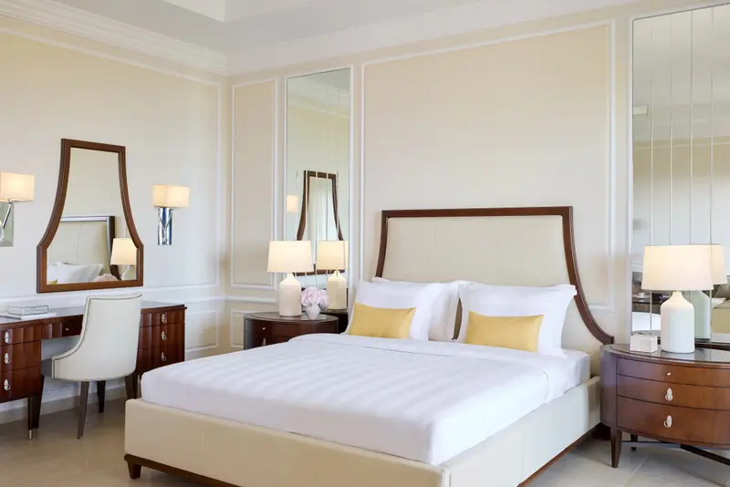 Une chambre lumineuse avec un grand lit et des meubles en bois.