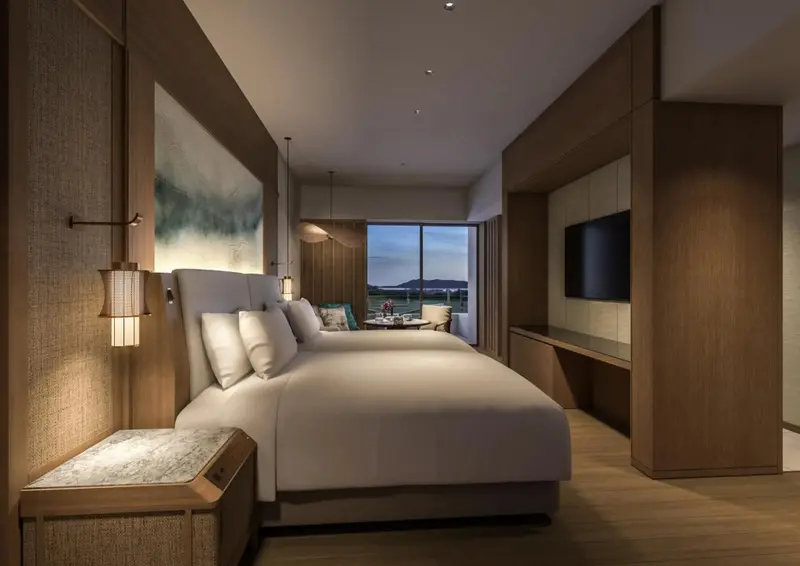 Une chambre lumineuse avec deux lits et une vue sur un paysage.