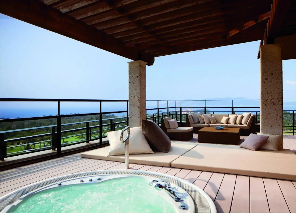 Espace de détente extérieur avec salon et jacuzzi face à la mer.