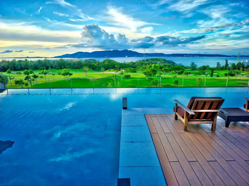 Une piscine à débordement offre une vue sur la mer et un paysage verdoyant.