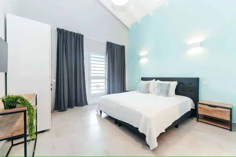 Une chambre lumineuse avec un grand lit recouvert de linge blanc.
