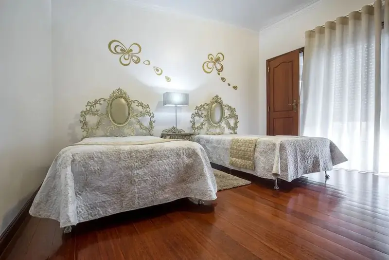 Deux lits simples décorés dans une chambre lumineuse.
