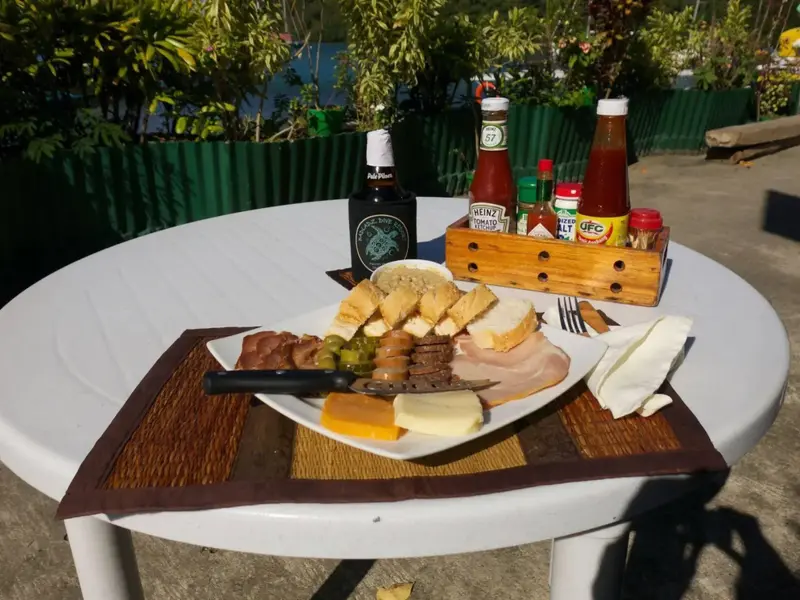 Assiette de charcuterie et de fromages sur une table en extérieur.