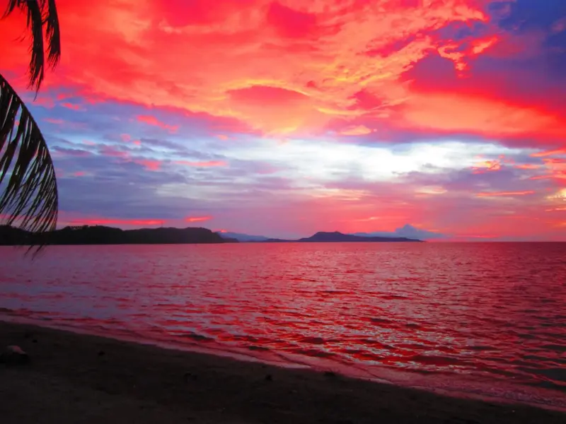 Coucher de soleil flamboyant sur une plage tropicale.