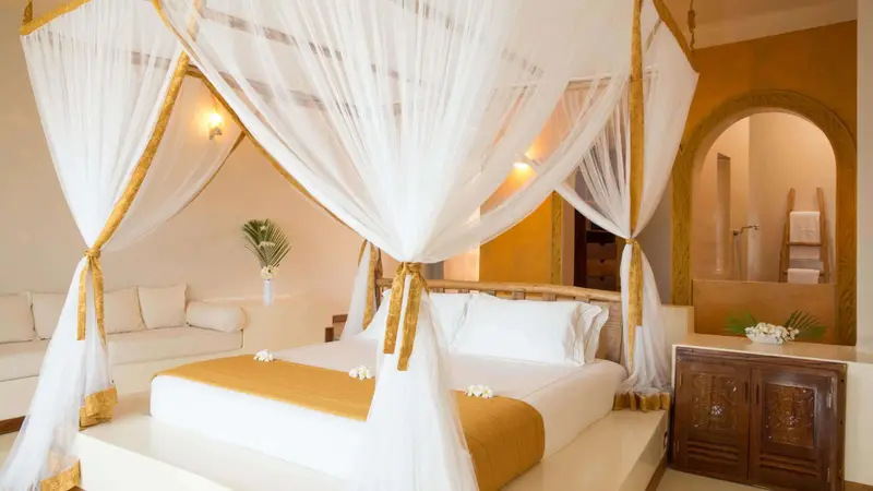 Une chambre lumineuse avec un lit à baldaquin et une décoration florale.