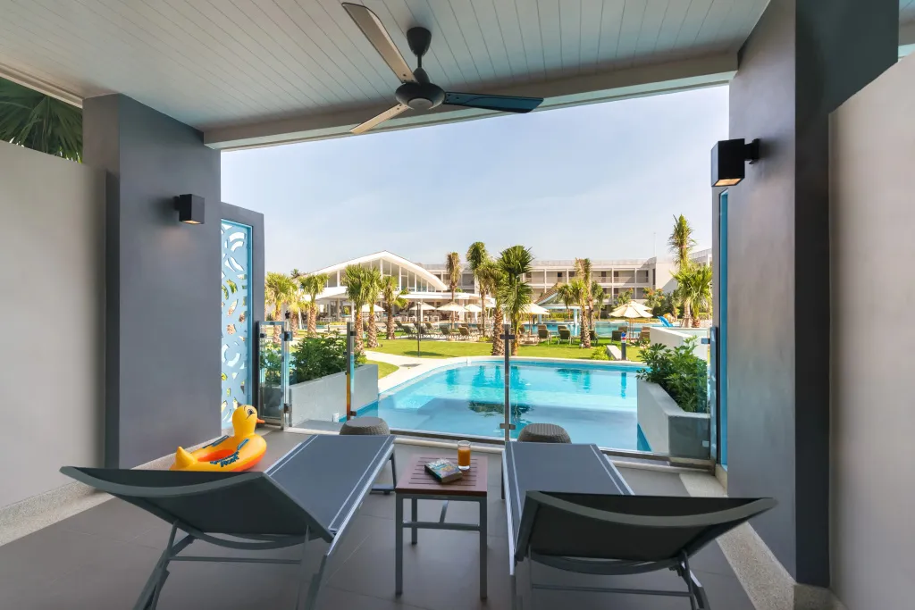 Vue sur une piscine depuis une terrasse ombragée.