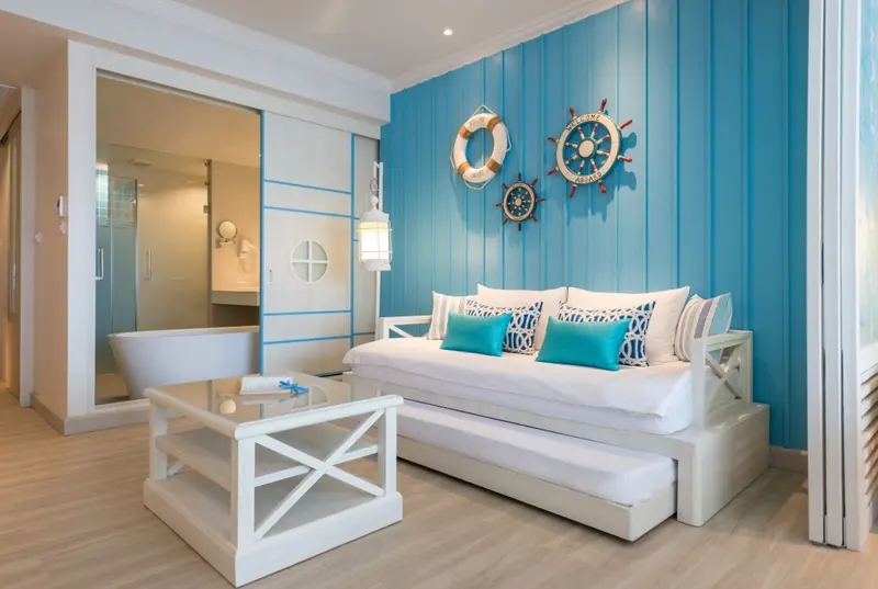 Espace de détente lumineux avec canapé blanc et décoration marine.