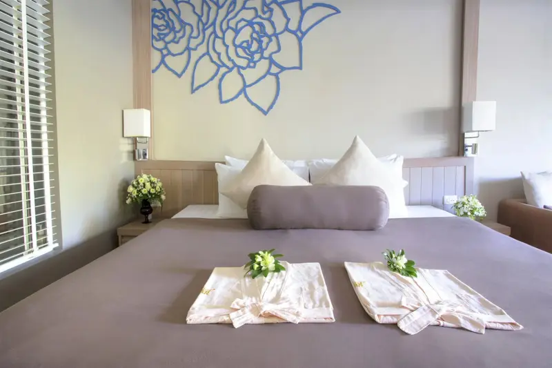 Une chambre lumineuse avec un grand lit décoré de fleurs.