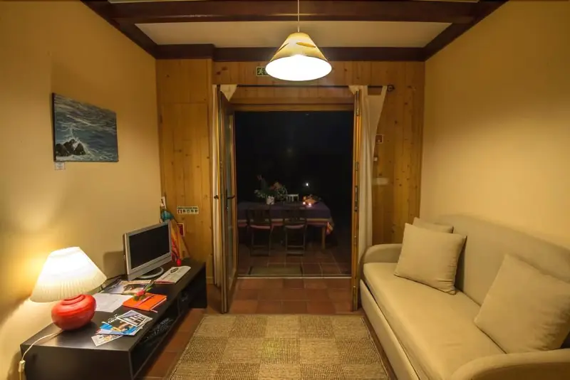 Un espace de vie intérieur lumineux avec un canapé et un accès à une terrasse.
