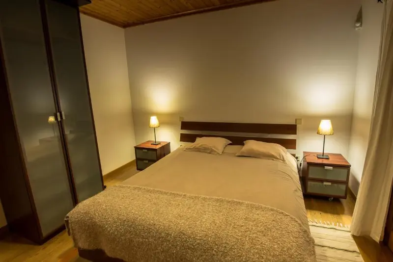Une chambre lumineuse avec un grand lit et des meubles en bois.