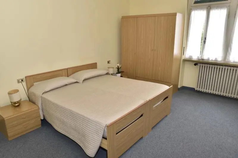 Une chambre lumineuse avec un grand lit et une armoire en bois.