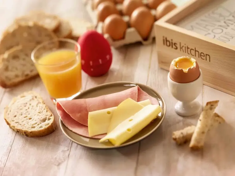 Un petit-déjeuner continental est présenté sur une table en bois clair.