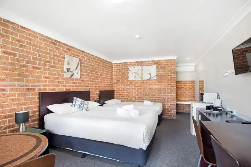 Une chambre lumineuse avec un grand lit et un coin repas.