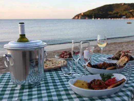 Une table dressée avec des plats et des boissons en bord de mer.